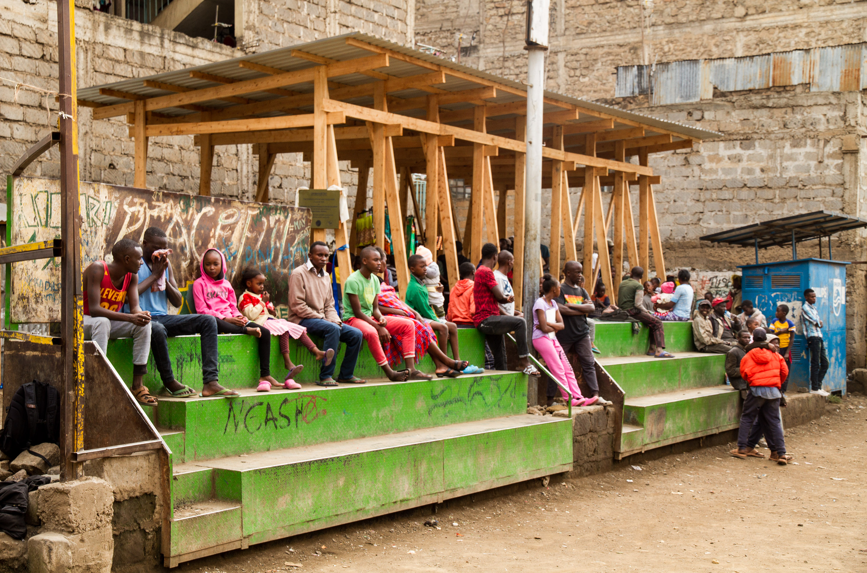 Memebers of the community sit infront of the new play space