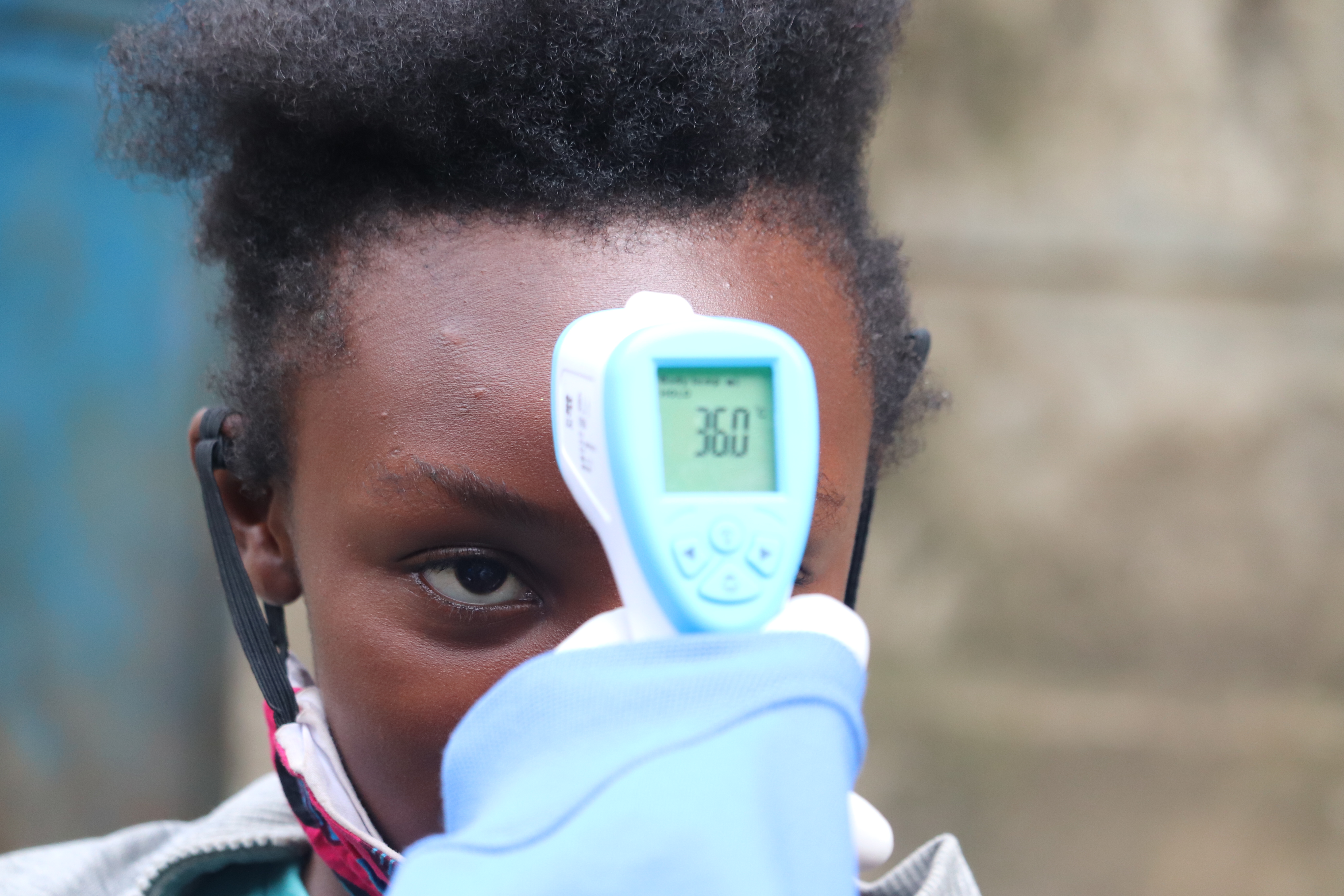 Temperature taking near the UN-Habitat supported handwashing facilities as part of  measures to prevent the spread of COVID-19 in the Mathare informal settlement, Nairobi, Kenya May 2020 © UNHabitat/Isaac Muasa