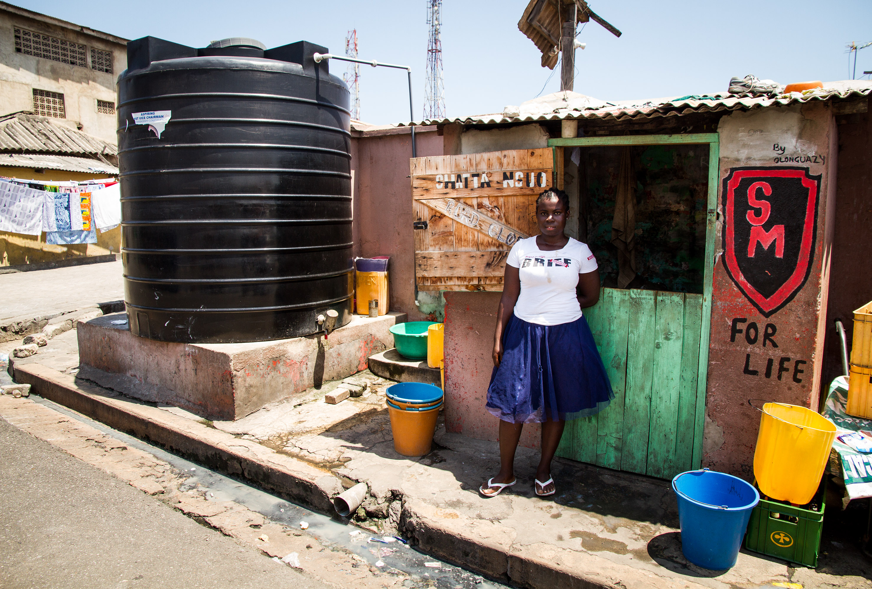 A woman outside a community run water facility in Old Town, Accra Ghana. 