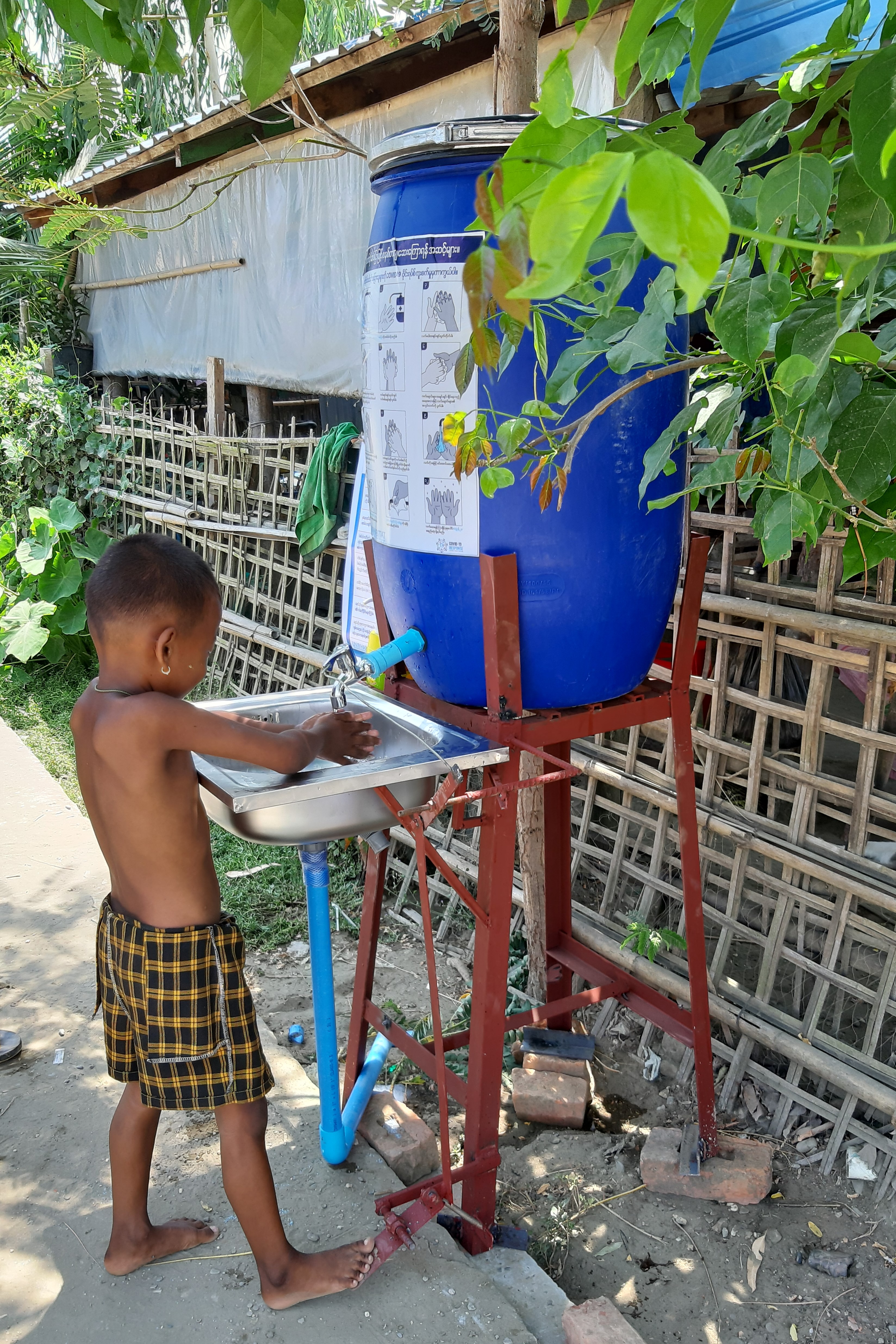 A child learns how to use the hands-free, foot pedal operated handwashing stations provided by UN-Habitat for COVID-19 prevention in Sittwe, Myanmar ©UN-Habitat /San Shwe Kyaw