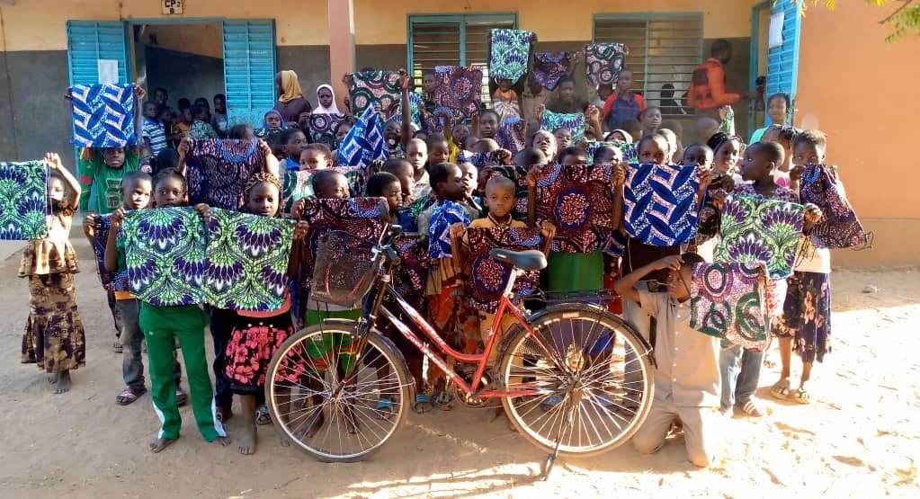 Children hold up tissue-made bags, meant to be replacement for plastic bags, produced by local women who were part of a skill development programme provided by ANZD and Ludwigsburg.